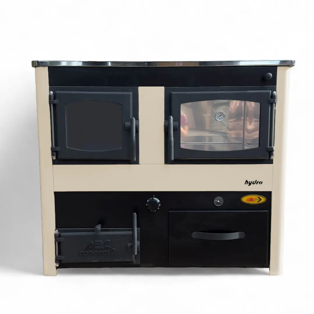 A compact freestanding wood-burning stove and oven unit with a cream-colored frame and black front panels, shown against a plain white background. The unit features two upper oven doors, a lower door, a control knob, and a small yellow-and-red warning label on the right side.