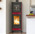 A tall black and red wood-burning stove with a glass door and an active fire inside, positioned in a kitchen setting next to a countertop with lemons.