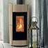 A modern wood-burning stove with a down frame and a black glass front showing a glowing fire, set against a white paneled wall next to a silver lantern and gray curtains.