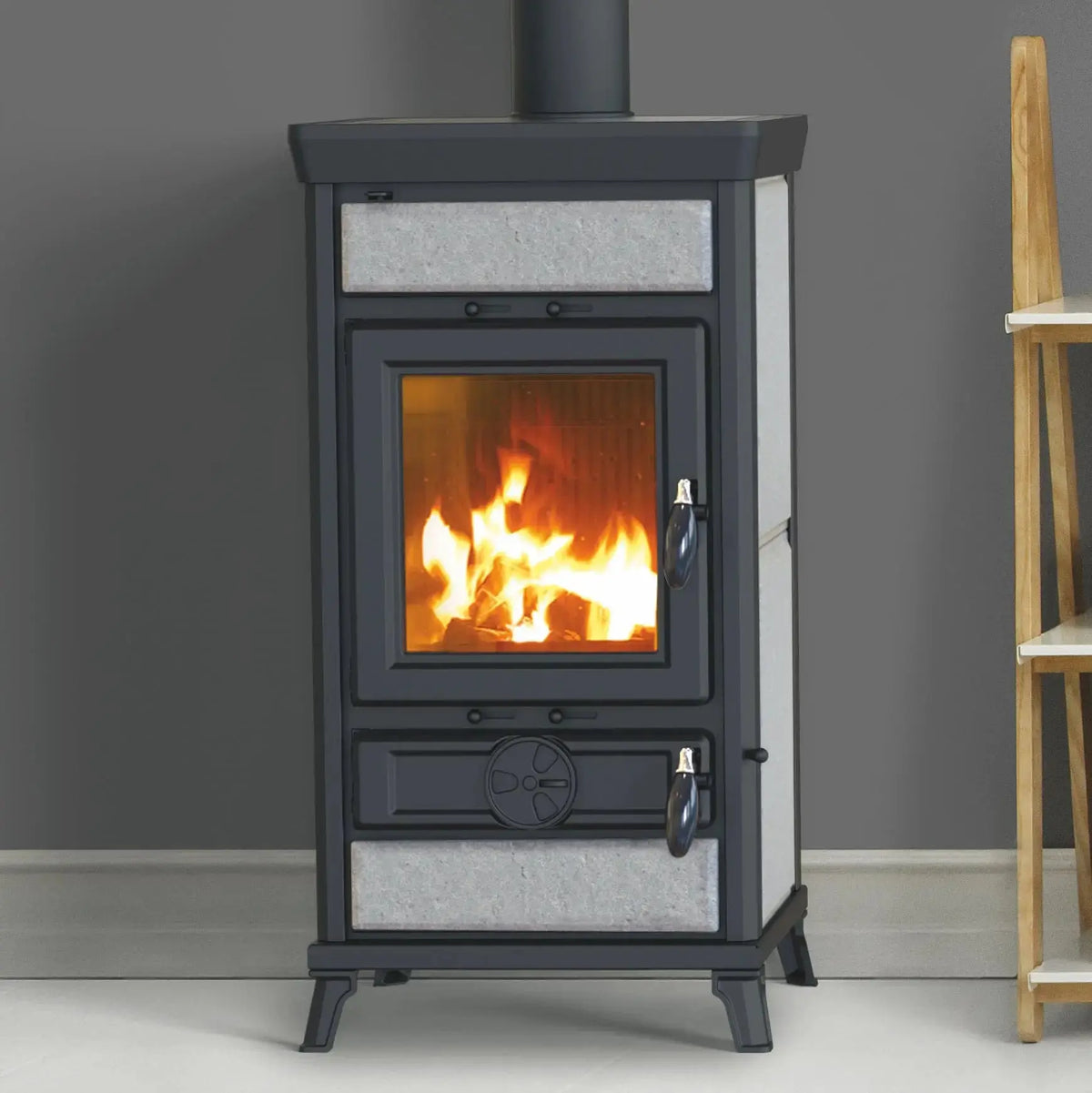 Wood burning stove with flames inside, placed against a gray wall.