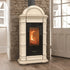 An beige freestanding wood-burning stove with a black glass front door showing a fire, set against a rustic stone wall and wood floor.