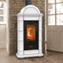 A white freestanding wood-burning stove with a black glass door showing a fire, set against a stone wall and wooden floor.