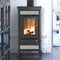 A black wood-burning stove with a glass door showing a warm fire, set in a room with dark wood floors and white walls.