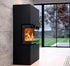 A modern black modular fireplace with an active fire burning inside, set against a textured gray wall next to large glass sliding doors showing a green garden outside.