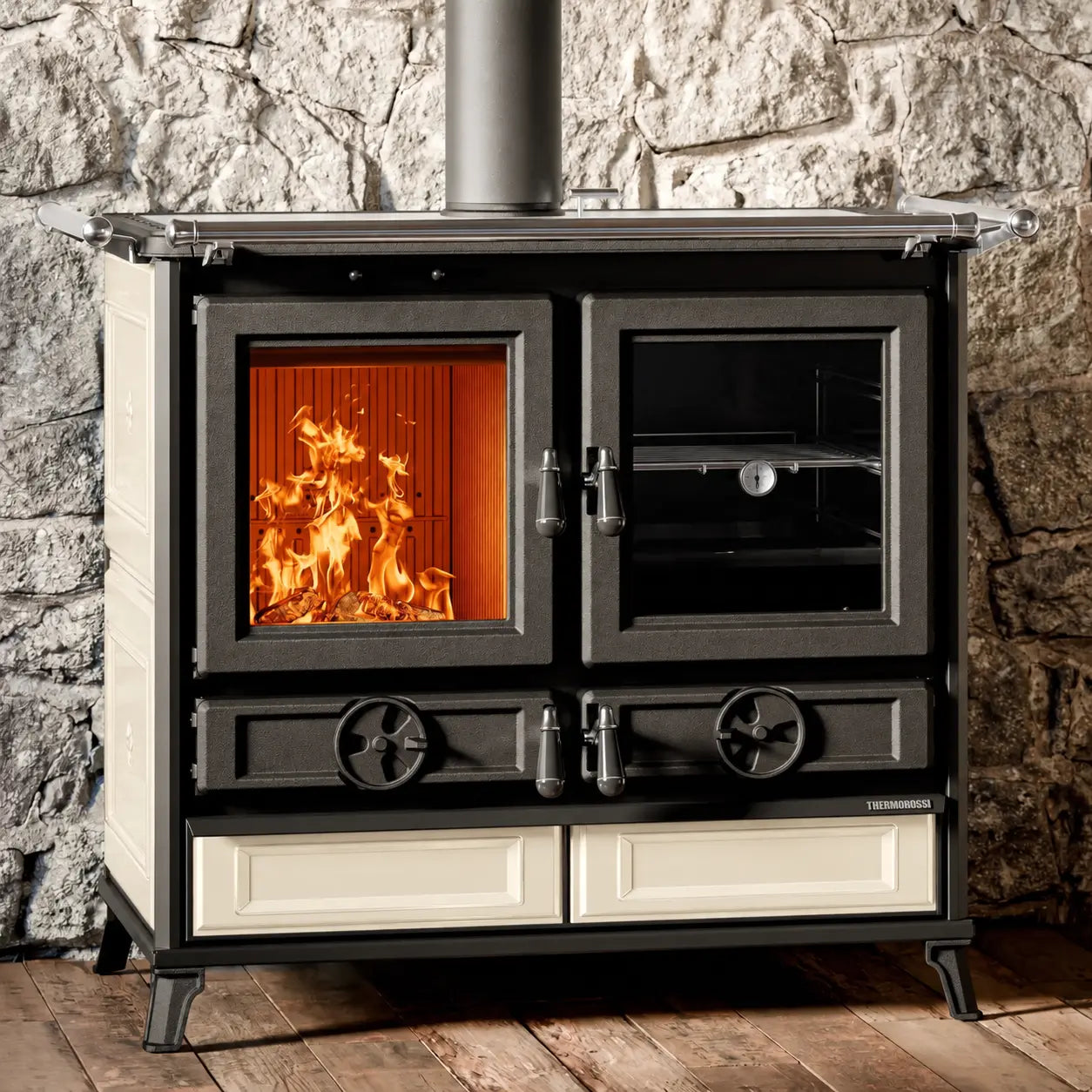 A black cast iron wood-burning stove with beige side panels and drawer fronts, set against a rustic stone wall and wooden floor. The left door shows a glowing orange fire inside, while the right door has a glass window showing interior shelves.