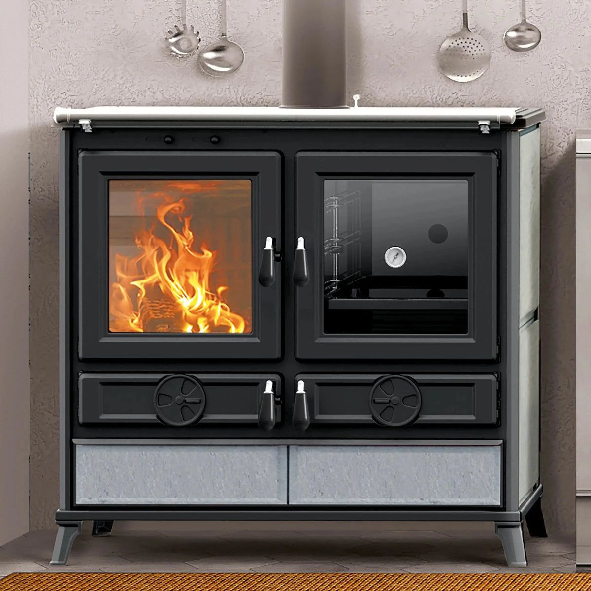 A black freestanding wood-burning stove with glass doors, shown lit with visible orange flames. The stove has two upper doors, two lower drawers with decorative circular details, and a light gray stone base panel.