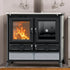 A black freestanding wood-burning stove with glass doors, shown lit with visible orange flames. The stove has two upper doors, two lower drawers with decorative circular details, and a light gray stone base panel.